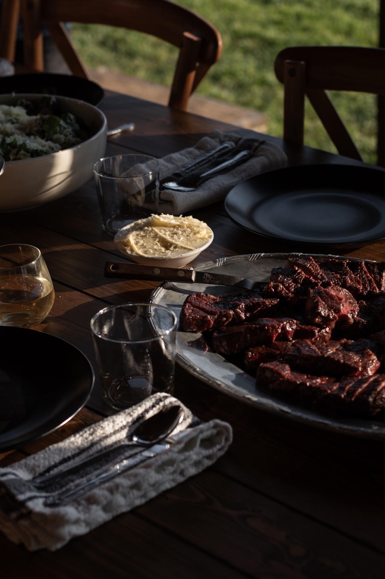 A set table at golden hour with wine and shared plates